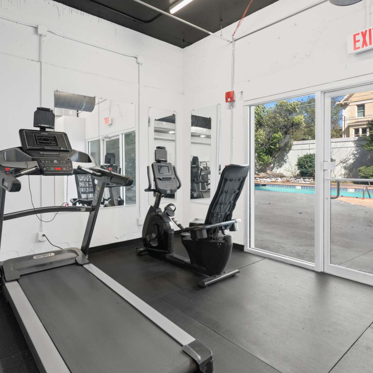 Fitness center overlooking the pool at Central Gardens Apartments